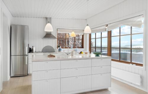 a kitchen with white cabinets and a large window at Holiday Home Tornehagen Holbæk Ii in Holbæk