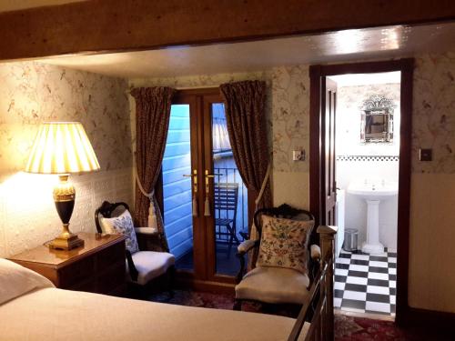 a bedroom with a bed and a chair and a lamp at The Lonsdale in Blackpool