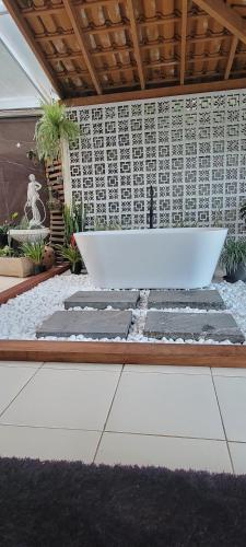 a white bench in the middle of a garden at Recanto das Orquídeas Domingos Martins- Soido De Cima,4km centro in Domingos Martins