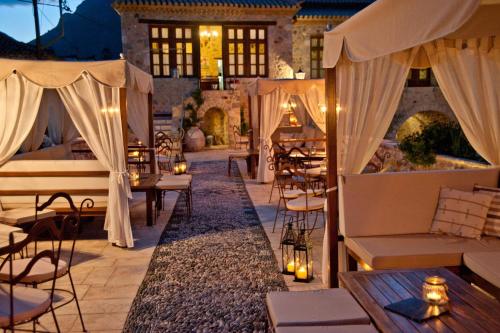 a patio at a hotel with tables and chairs at Archontiko Hatzipanayioti in Leonidion
