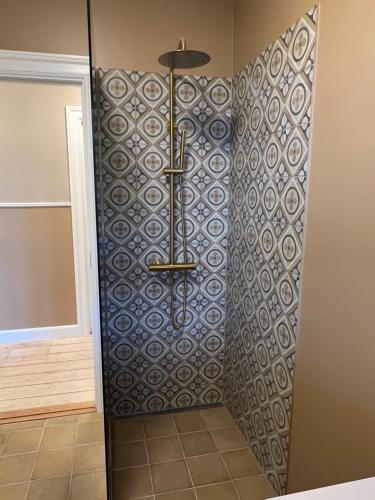 a shower in a bathroom with a tile wall at Byhuset - Hems 60 in Vejle