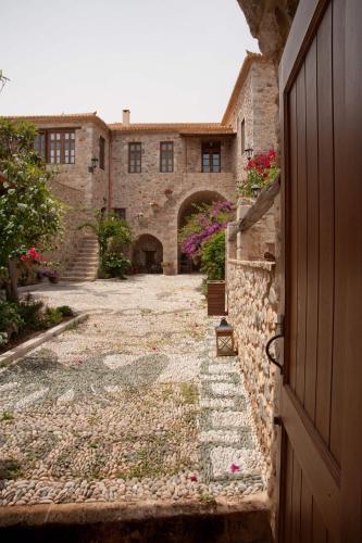 an entrance to a stone building with a door at Archontiko Hatzipanayioti in Leonidion
