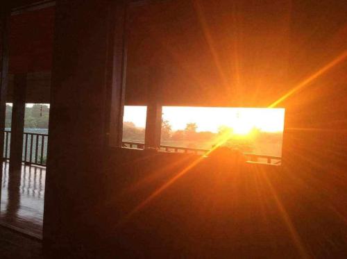 a sun shining through a window of a house at Rai Phuchat in Ban Pa Thon