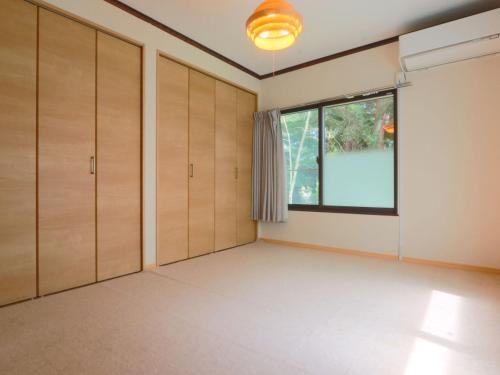 an empty room with wooden cabinets and a window at リゾートハウス正波2 in Azumino