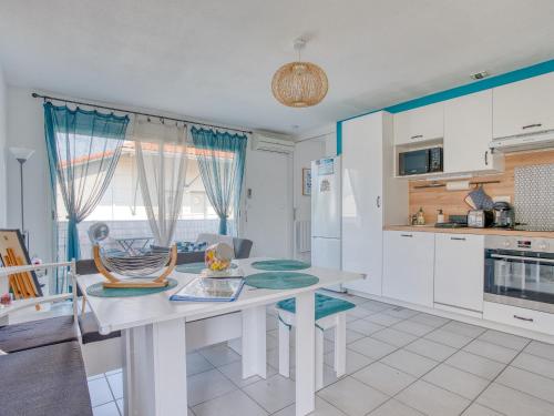 a kitchen with a white table and a dining room at Charmant T2 avec terrasse, climatisation et WIFI - Quartier résidentiel à Biscarrosse - FR-1-521-217 in Biscarrosse