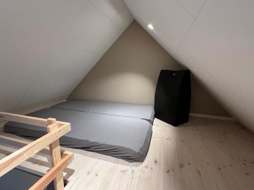 a small bedroom with a bed in a attic at Byhuset - Hems 60 in Vejle