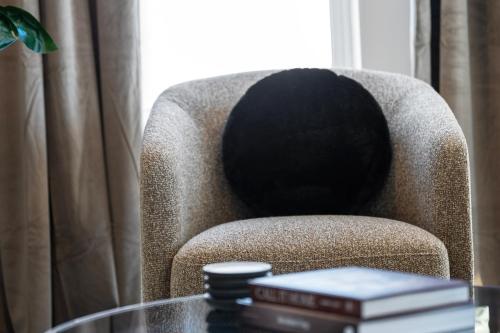 a black hat sitting on a chair with a glass table at Luxury Furnished Apartments by Hyatus Downtown at Yale in New Haven
