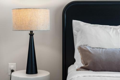 a lamp sitting on a table next to a bed at Luxury Furnished Apartments by Hyatus Downtown at Yale in New Haven