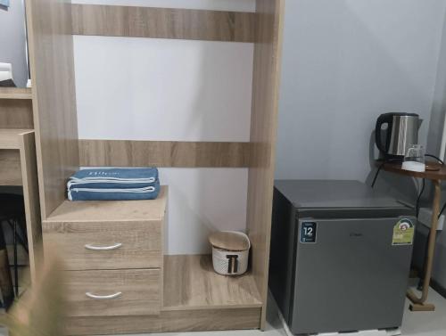 a room with a desk with a small refrigerator at คาเฟ่ เดอ แจ่วบอง รูมแอนด์เซอร์วิส in Khon Kaen