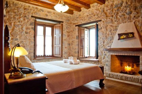 a bedroom with a bed and a fireplace at Archontiko Hatzipanayioti in Leonidion
