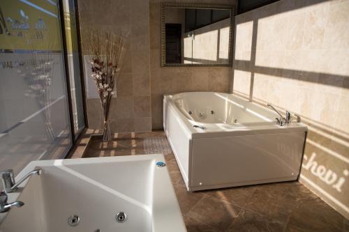 ein Badezimmer mit einer weißen Badewanne und einem Waschbecken in der Unterkunft Hotel-Clinic Dr. Gechevi in Pavel Banya