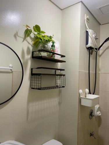 a bathroom with a toilet and a sink and a mirror at Condo near ATC- Molito Alabang, Muntinlupa in Manila