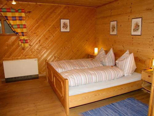 a bedroom with a bed in a wooden cabin at Haus Anneliese in Mühlbach am Hochkönig