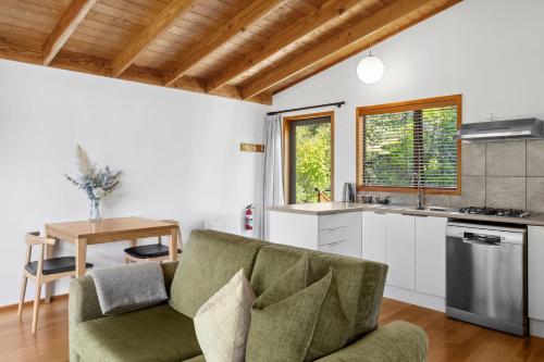 a living room with a couch and a table at Adrift In Golden Bay- Absolute Beachfront Villas in Collingwood