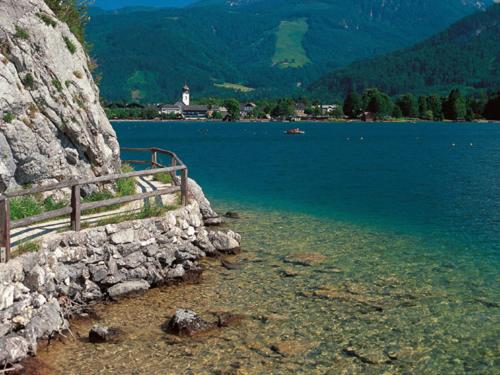 a large body of water with a stone wall at Reiterhof Suassbauer in St. Wolfgang