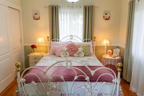 a bedroom with a bed with two teddy bears on it at Milford Country Cottages in Milford