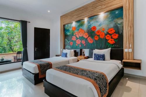 two beds in a room with a painting on the wall at Dewangga Ubud in Ubud