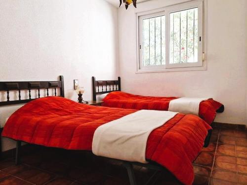 zwei Betten mit roten und weißen Decken in einem Zimmer in der Unterkunft Casa Rubens – Vistas al mar | Playa a 7 min | Parking - ES-258-104 in Roses
