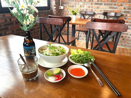 a table with two bowls of salad and a drink at Sapa Riverside Homestay in Sa Pa