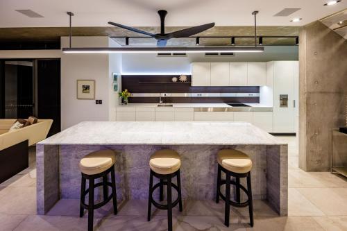 a kitchen with a marble counter and stools at The Tap In in Craiglie