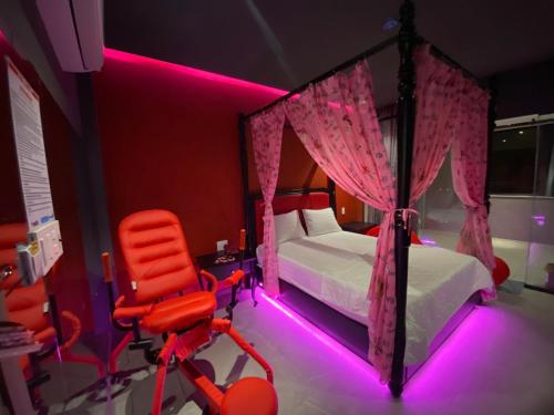 a bedroom with a bed and a red chair at khách sạn tina 5 in Can Tho