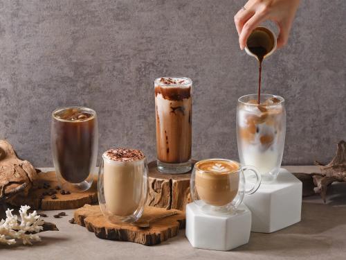 a person is pouring coffee into four different coffeeinis at DoubleTree by Hilton Bangkok Ploenchit in Bangkok