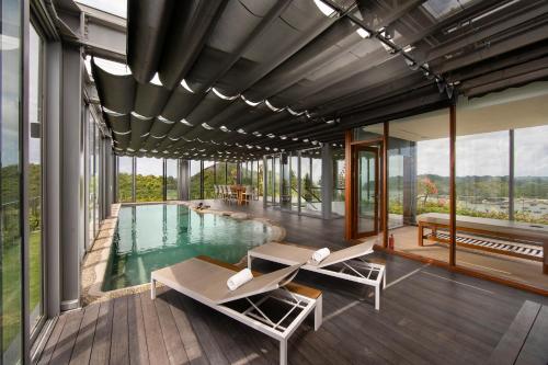 a house with a pool and a deck with chairs at Flamingo Resort Cat Ba in Cat Ba