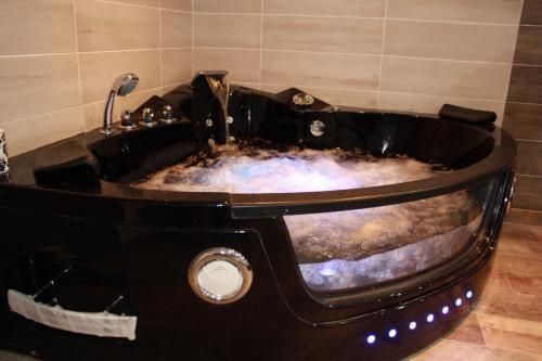 a large black bath tub in a bathroom at Appart'hôtel Art Deco in Cannes