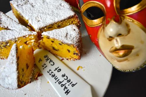 a plate with a piece of cake and a mask at Petit Hotel in Lido di Camaiore