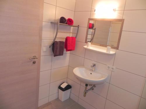 a white bathroom with a sink and a mirror at Stockers Apart in Umhausen