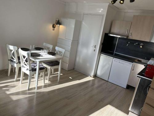une cuisine avec une table et des chaises dans une pièce dans l'établissement Studio 4 pers à l'Alpe d'Huez avec balcon et animaux acceptés - FR-1-405-366, à Huez