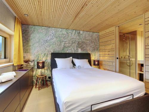 a bedroom with a large white bed and a shower at Chalet neuf à Courchevel 1850, prêt pour 6 avec ski aux pieds et wifi! - FR-1-575-233 in Courchevel