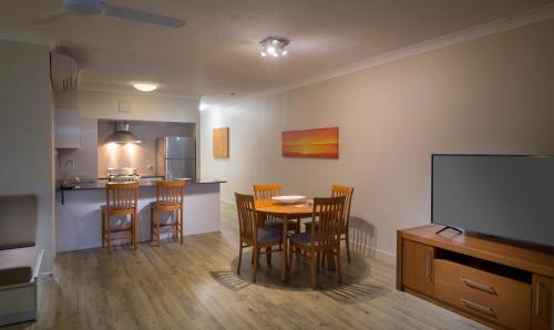 a kitchen and dining room with a table and chairs at Whitsunday Apartments in Hamilton Island