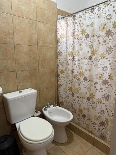 Un baño con inodoro y cortina de ducha. en Tu lugar de descanso III, en Federación