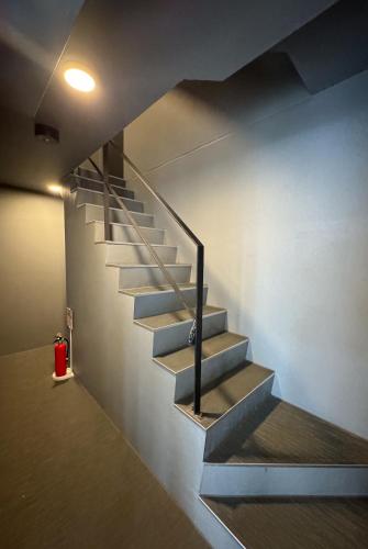 a staircase in a room with a red fire extinguisher at trias 302 in Tokyo