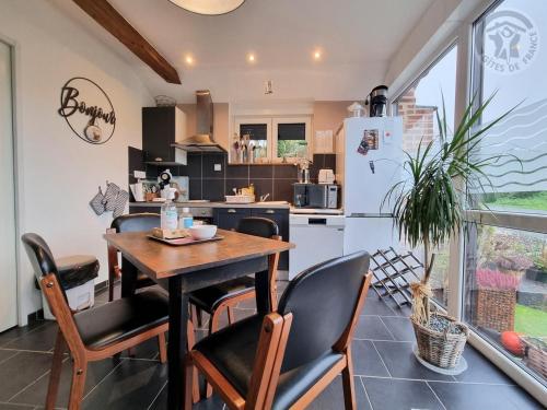 une cuisine et une salle à manger avec une table et des chaises dans l'établissement Gîte familial tout inclus avec cour, terrasse et équipements équestres, proche du Parc Naturel de l'Avesnois - FR-1-510-190, à Villers-Pol