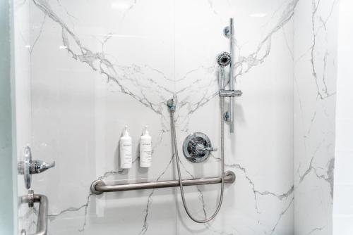 a shower with two shampoo bottles on a wall at Pacific Inn and Suites in San Pedro