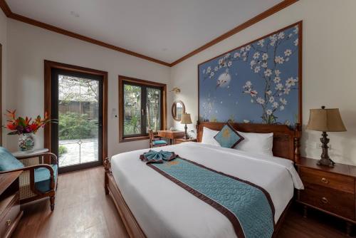 a bedroom with a large bed with a large painting on the wall at Indochine Boutique Hotel Ninh Bình in Ninh Binh