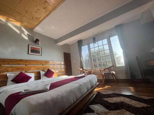 a bedroom with a large bed and a large window at Bahar Retreat And Spa , Gangtok in Gangtok