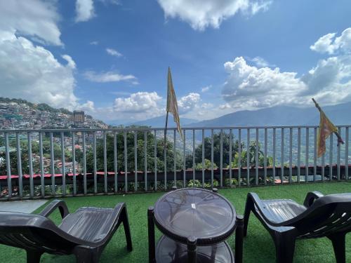 a table and chairs on a balcony with a view at Bahar Retreat And Spa , Gangtok in Gangtok