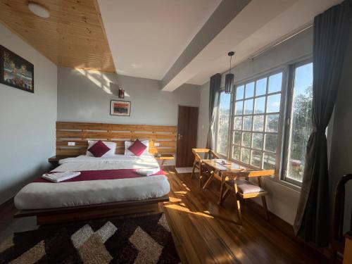 a bedroom with a bed and a desk and a window at Bahar Retreat And Spa , Gangtok in Gangtok