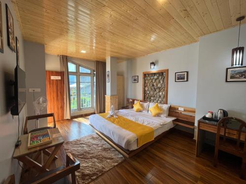 a bedroom with a large bed and a wooden ceiling at Bahar Retreat And Spa , Gangtok in Gangtok