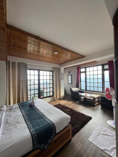 a bedroom with a large bed and a living room at Bahar Retreat And Spa , Gangtok in Gangtok
