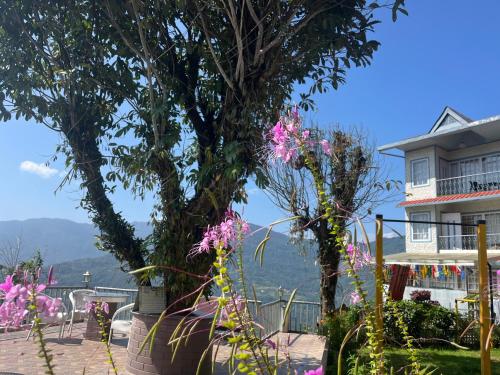 a building with trees and flowers in front of it at Bahar Retreat And Spa , Gangtok in Gangtok
