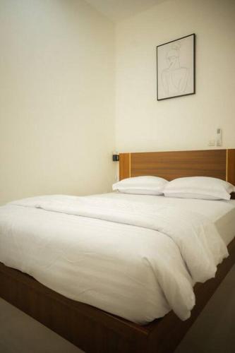 a bedroom with a large bed with white sheets and pillows at Bylina House in Batu