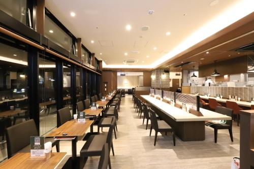 a restaurant with rows of tables and chairs at Citadines Harbour Front Yokohama in Yokohama