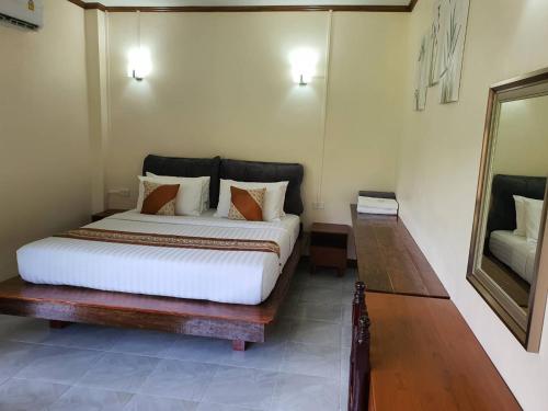 a bedroom with a bed and a mirror in it at Malulee KhaoSok Resort in Khao Sok