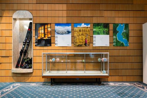 a bench on a wall with posters on it at Hotel K Yuzawa 越後湯澤溫泉旅館 in Yuzawa