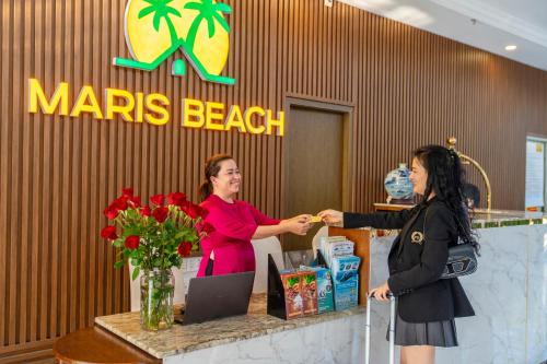 two women shaking hands at a marias beach counter at Maris Beach Hotel Phu Quoc in Phu Quoc