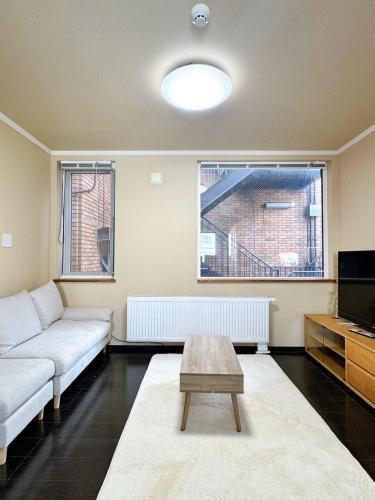 a living room with a couch and a coffee table at 北海道大学ENYA-n17 in Sapporo